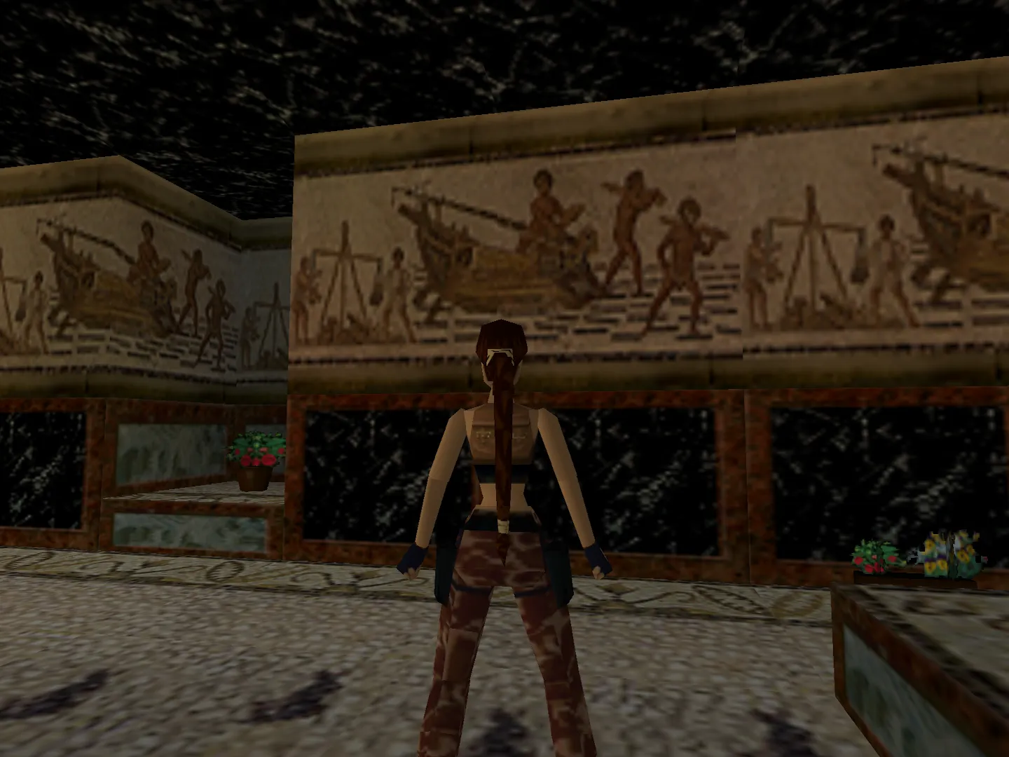 Capture d'écran du jeu Tomb Raider III. On y voit le personnage de Lara Croft dans son manoir, devant une mosaïque reprenant les motifs d'une mosaïque romaine découverte à Sousse, qui représente le déchargement d'un navire marchand
