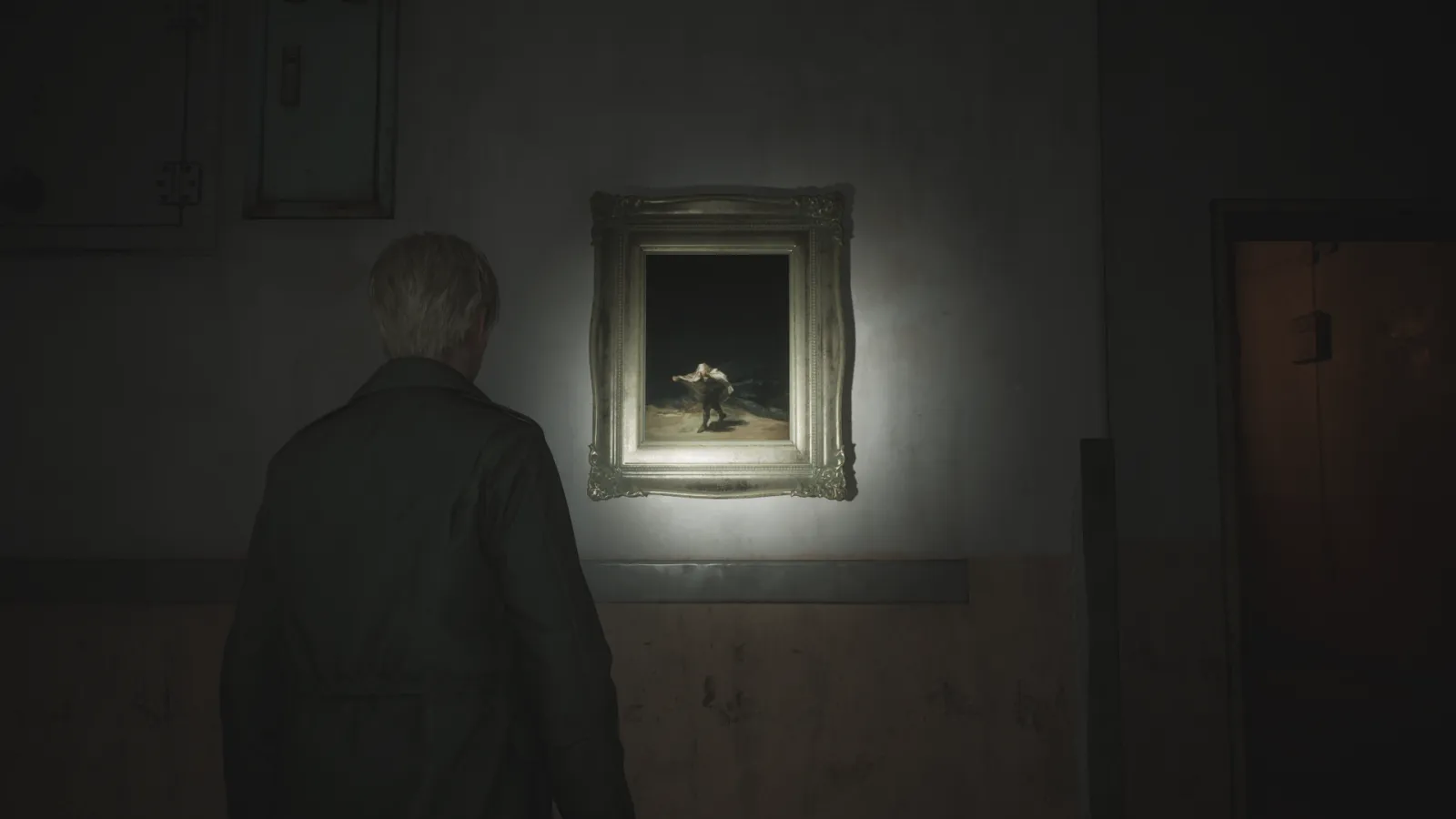 Capture d'écran de Silent Hill 2 qui montre le personnage de James Sunderland de dos. Il fait face à un mur auquel est accrochée une version modifiée du tableau "Le Vol des Sorcières" de Francisco de Goya