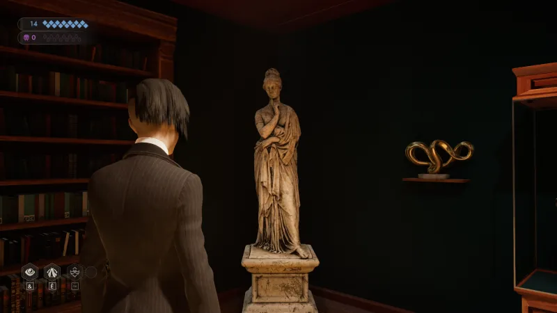 L'image est une capture d'écran du jeu vidéo Vampire: The Masquerade – Swansong. On y voit le personnage joueur de dos, debout dans une pièce aux murs couleur vert sapin. Le personnage joueur fait face à l'un des angles de la pièce, où on peut voir une sculpture en marbre représentant une femme debout, vêtue à l'antique. A gauche se dresse une bibliothèque remplie d'ouvrages, et à droite on peut voir une sculpture abstraite dorée accrochée au mur, ainsi qu'une vitrine.