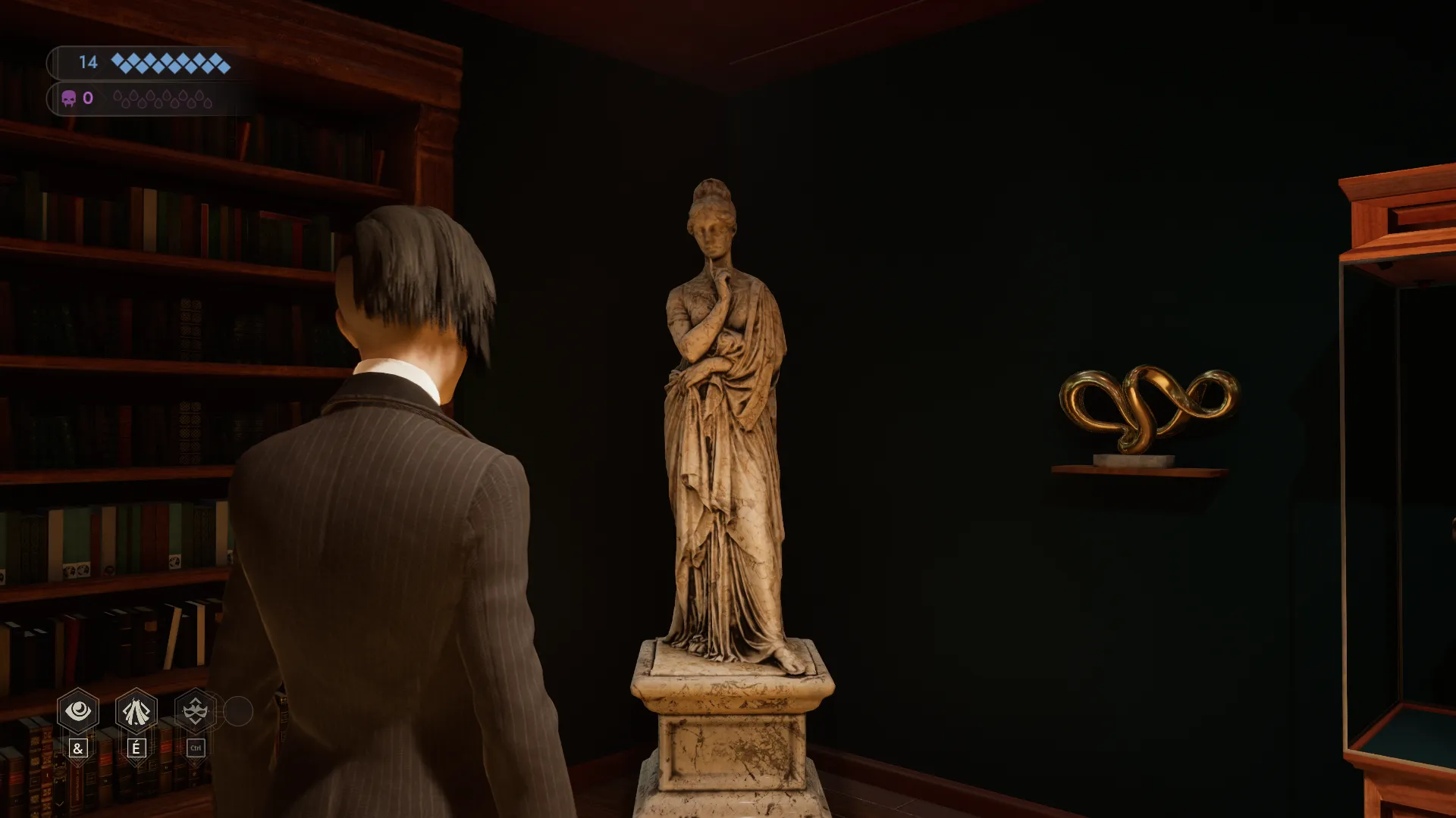 L'image est une capture d'écran du jeu vidéo Vampire: The Masquerade – Swansong. On y voit le personnage joueur de dos, debout dans une pièce aux murs couleur vert sapin. Le personnage joueur fait face à l'un des angles de la pièce, où on peut voir une sculpture en marbre représentant une femme debout, vêtue à l'antique. A gauche se dresse une bibliothèque remplie d'ouvrages, et à droite on peut voir une sculpture abstraite dorée accrochée au mur, ainsi qu'une vitrine.